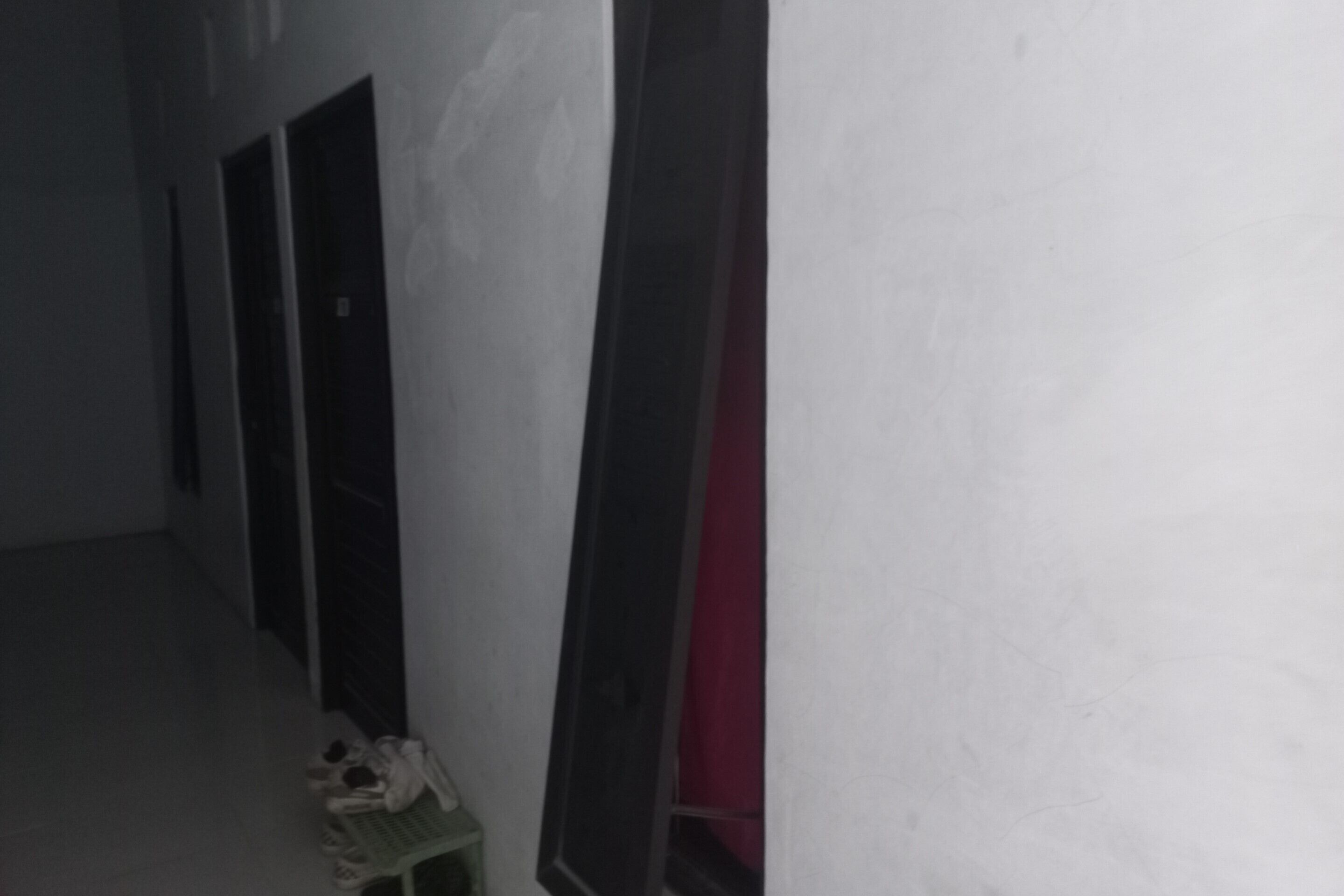 Un couloir étroit, avec des portes d’un côté et une fenêtre de l’autre.
