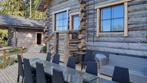 A log cabin with a deck featuring outdoor furniture and a staircase leading to the main building. - Kaunisvirta villa for 10 with beautiful views. Pet-Friendly! (Pyhtään kirkonkylä)