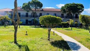 A building with a red-tiled roof, multiple balconies, and a pathway leading to the entrance. - Vita Blu Studios (Zakynthos)
