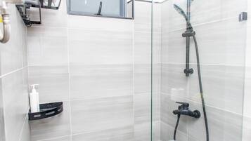 Een douche, handdoeken, zeep, toiletpapier