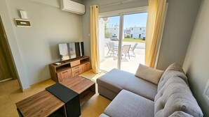 Una sala moderna con un sofá, una mesa de centro y un mueble para televisión.