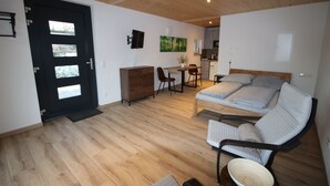 A modern room with a bed, a desk, and a dining area.