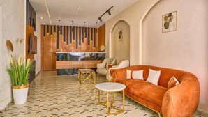 A lobby with a reception desk, seating area, and decorative wall panels. - Cleopatra Tower Pyramids Hotel (Giza)