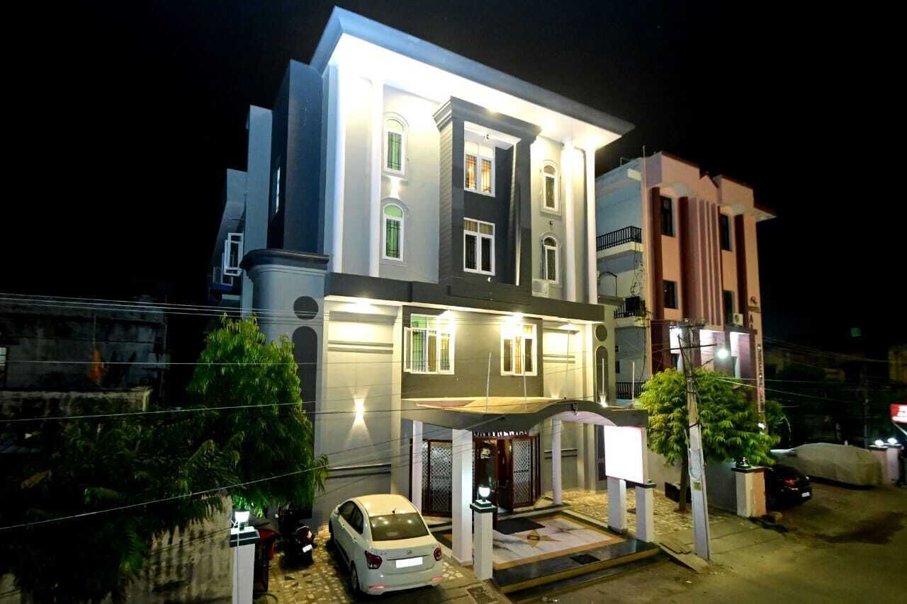 Un edificio de varios pisos con una entrada bien iluminada y un área techada al frente.