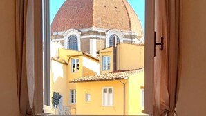 A room with a view of a building with a dome and yellow walls. - Bright Apartment a few steps from Duomo and Train Station. Wifi, A/C, W&D  (Firenze)