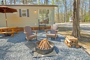 A cabin with a fire pit, outdoor seating, and a grill.
