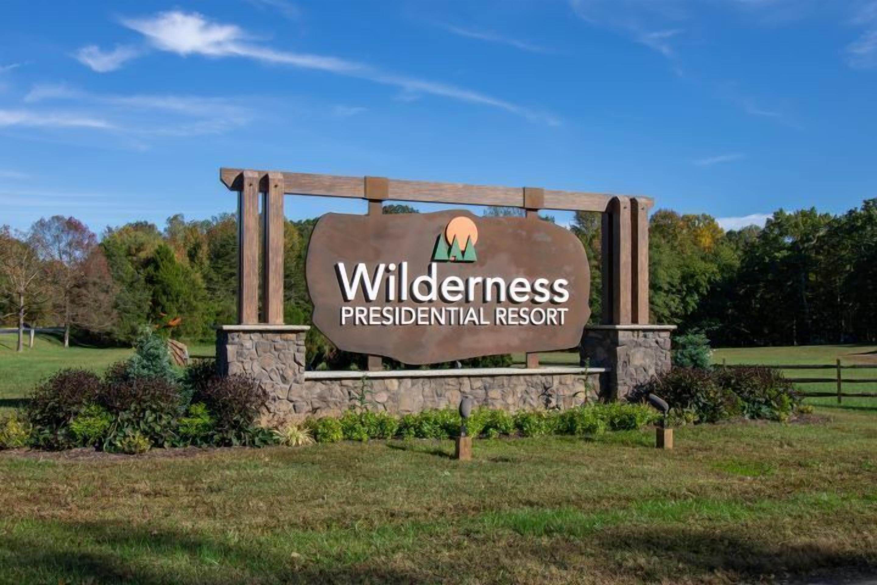 Une enseigne pour le Wilderness Presidential Resort, avec un logo représentant une montagne.