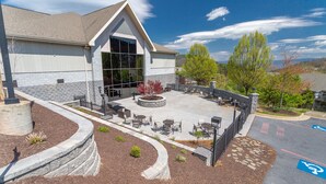 A building with a patio area featuring outdoor seating and a stone wall.