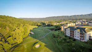 A golf course with a large building adjacent to it. - The Summit Two Bedroom Condo (Mc Gaheysville)