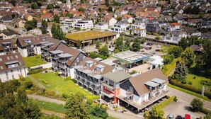 Een woongebied met moderne appartementencomplexen, een tankstation en een treinstation.