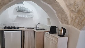Een kleine keuken met een inbouwvaatwasser, een spoelbak en een kookplaat.