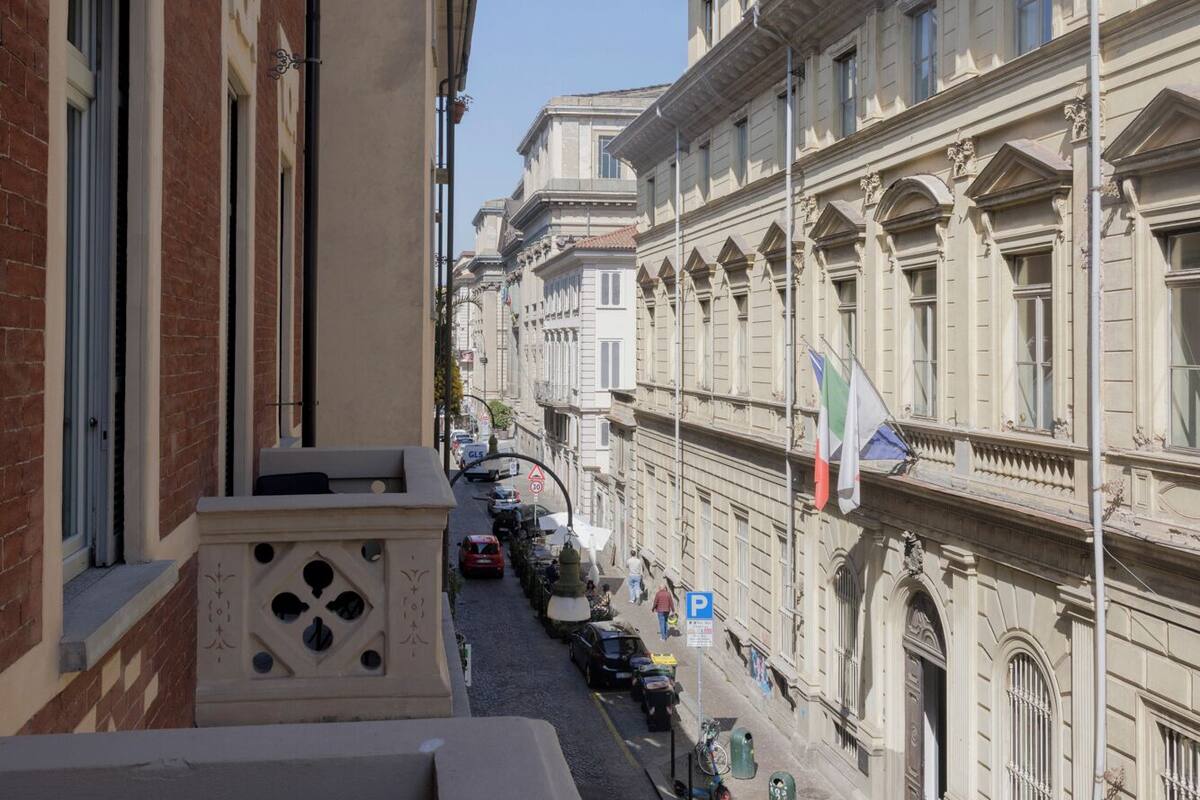 Una calle estrecha bordeada por edificios históricos, con cielo despejado.