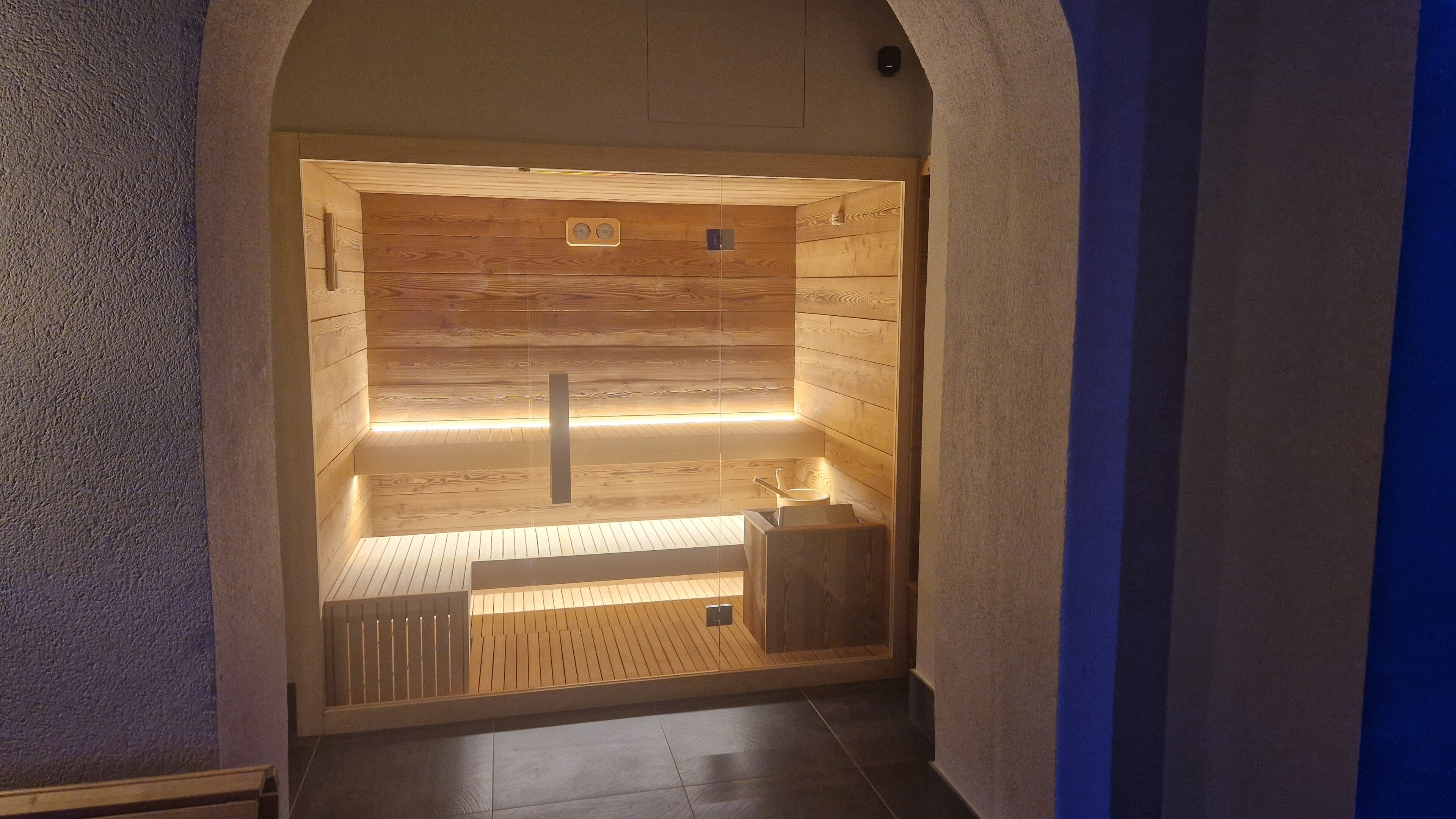 A sauna with wooden walls, a bench, and a small sink.