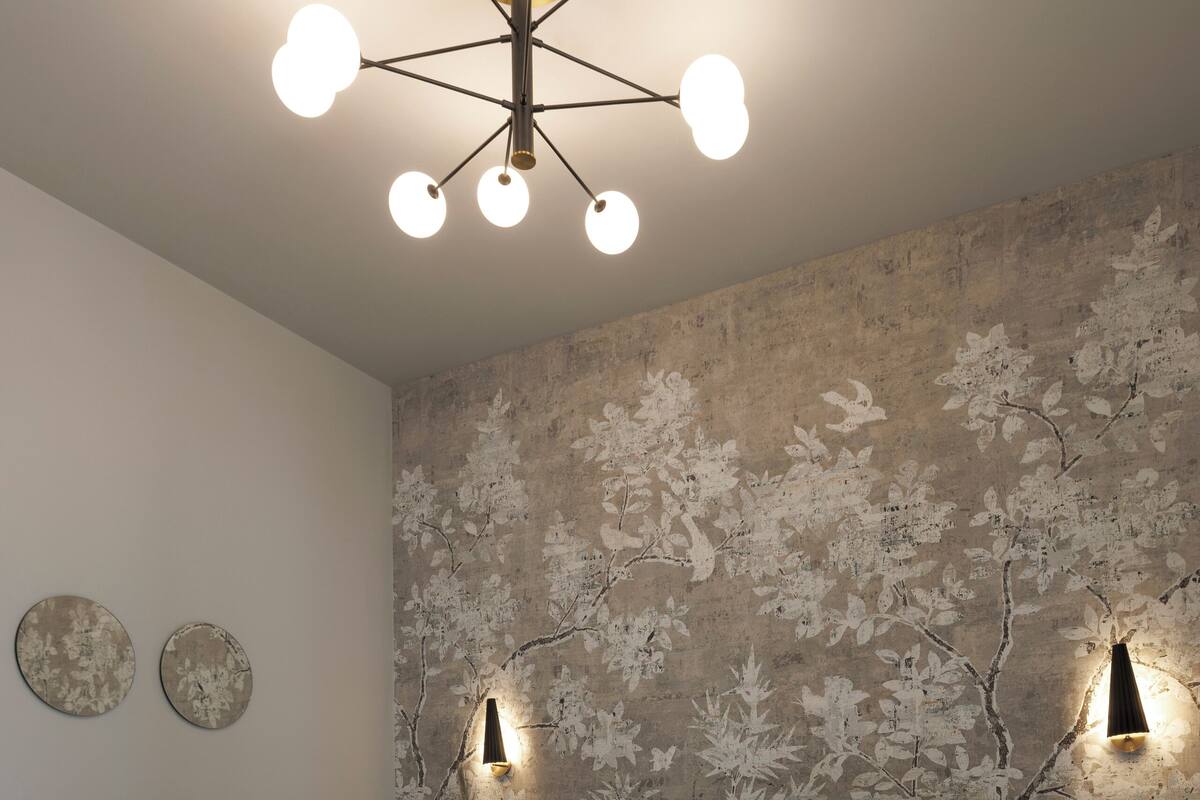 Un dormitorio moderno con una cama grande, un mural original en la pared y una lámpara de techo contemporánea.