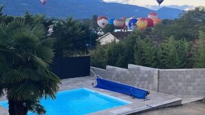 Een zwembad met luchtballonnen op de achtergrond.