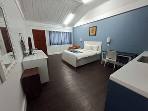 A hotel room with a bed, desk, chair, and a window with curtains. - Bolabog Beach Resort (Boracay Island)