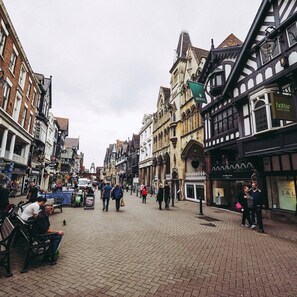 A historic street with traditional architecture, shops, and pedestrians.