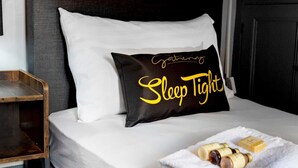 A neatly made bed with a pillow featuring the text "Gathering Sleep Tight." - The Lombard House - City Centre (Chester)