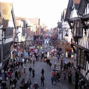 A crowded medieval street with narrow pathways and traditional timber-framed buildings. - The Kings Gathering - Very Central Chester (Chester)