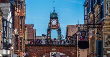 A historic clock tower with a crowd of people in front.