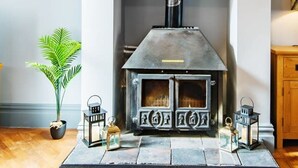 A modern living room with a stone fireplace, a potted plant, and decorative lanterns. - The Kings Place - Very Central Chester - Chester (Chester)