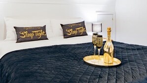 A hotel room with a bed, two pillows, a tray with a bottle and glasses, and a nightstand. - The Kings Place - Very Central Chester - Chester (Chester)
