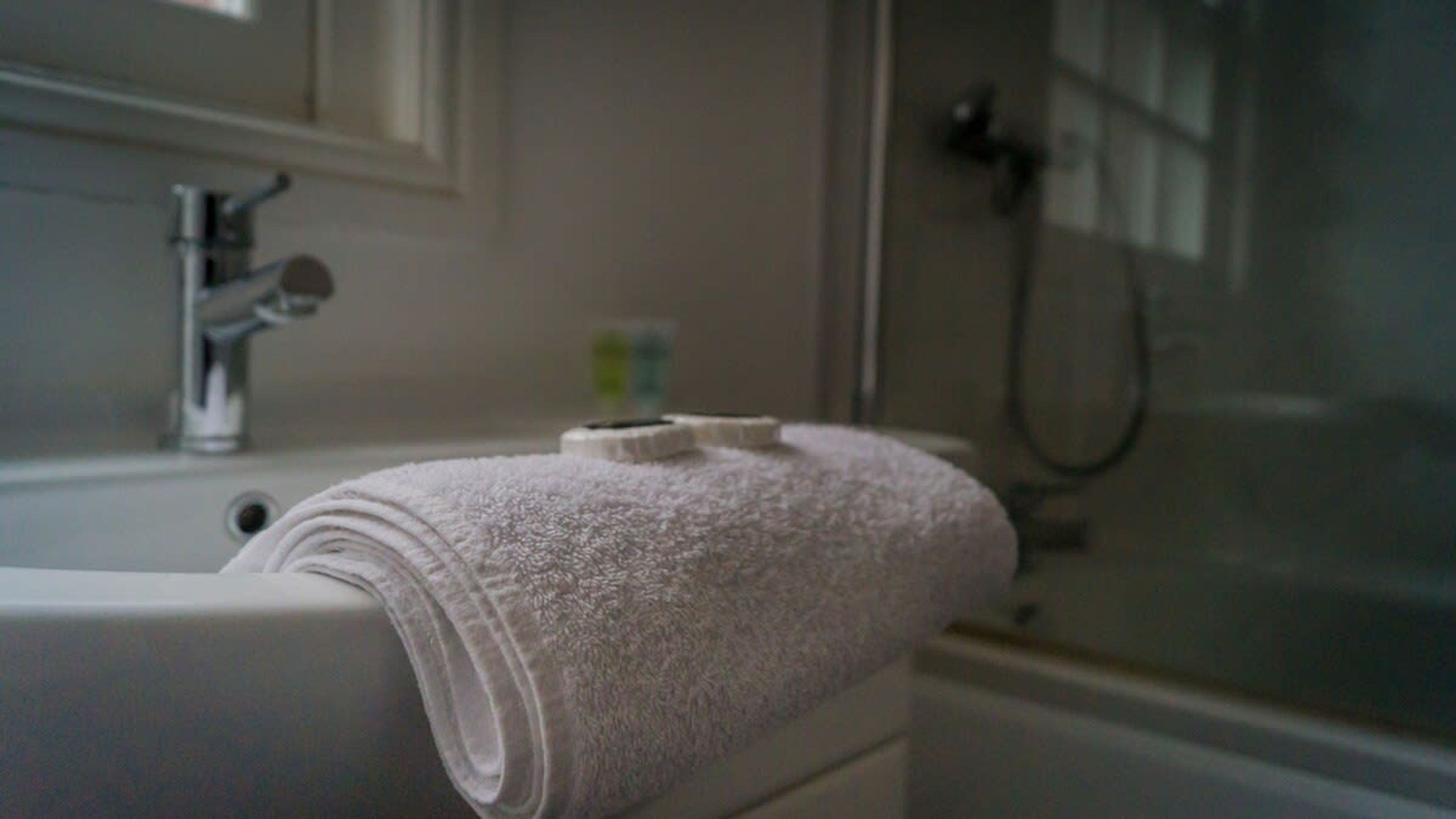 Un baño con una bañera blanca, una toalla y una cabina de ducha de vidrio.