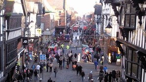 Eine belebte mittelalterliche Straße mit engen Pfaden und traditionellen Fachwerkhäusern.