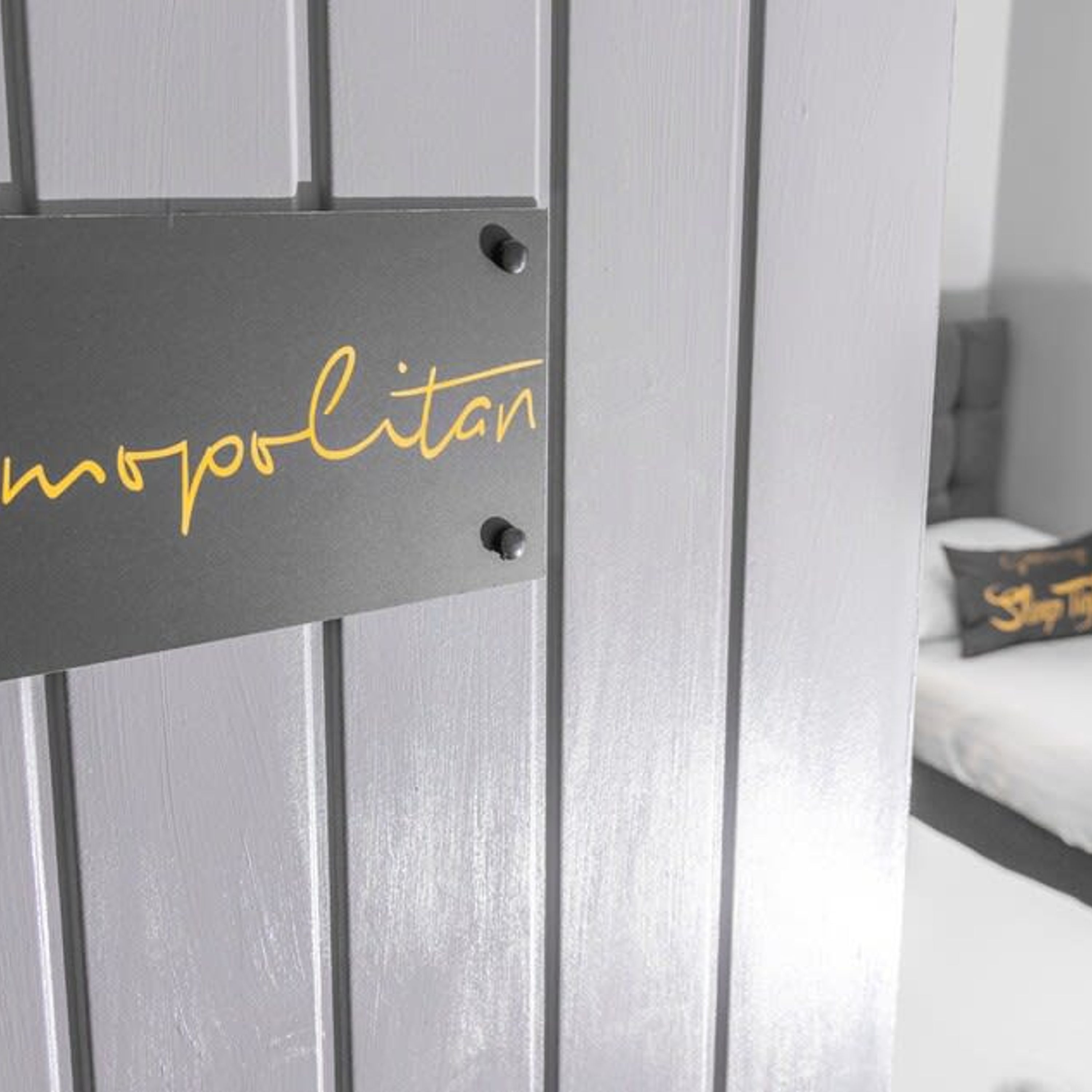 A door with a sign that reads "mopolitan" in gold lettering.