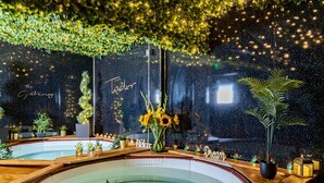 A spa area with a pool, surrounded by greenery and decorative lights. - The Tudor Gathering Chester - City Centre (Chester)