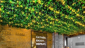 A restaurant with a brick wall and a poster that says "GATHER. ENJOY. REPEAT." - The Tudor Gathering Chester - City Centre (Chester)
