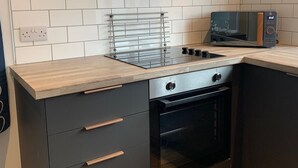 Une cuisine moderne équipée d’une cuisinière à gaz, d’un four et d’un four à micro-ondes.