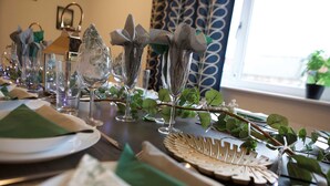 A table set with clear glassware, green napkins, and decorative foliage. - The Gathering Sale - Sleeps Up To 22 (Sale)