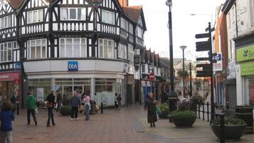 A traditional half-timbered building with a D&A sign, a pedestrian area, and shops.