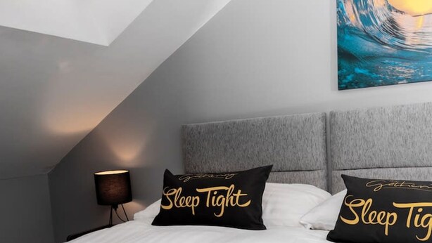 A neatly made bed with two pillows, each labeled "Sleep Tight," and two towels. - The Eisteddfod - Berwyn House Central Wrexham (Wrexham)