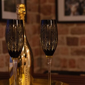 Two ornate wine glasses and a bottle of Bottega Gold wine on a tray.