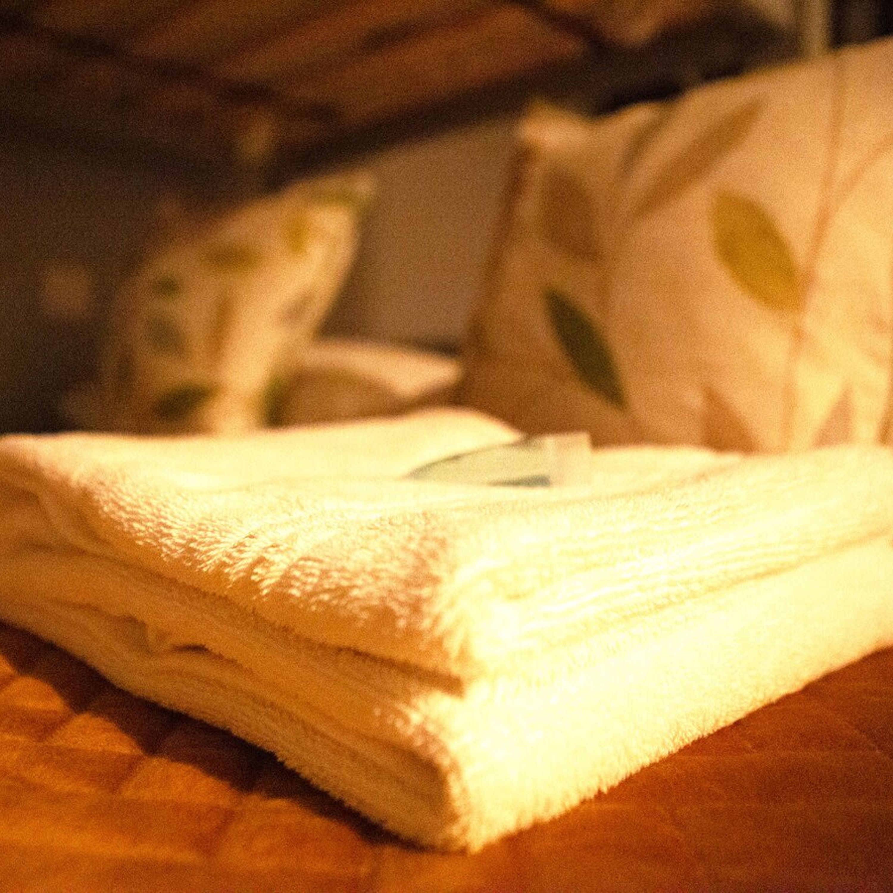 A neatly folded white towel on a wooden surface.