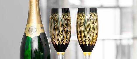 A bottle of champagne and two glasses with intricate designs.