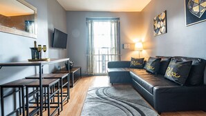 Un salon moderne comprenant un canapé, une table basse, un téléviseur et un coin repas avec une table et des chaises.