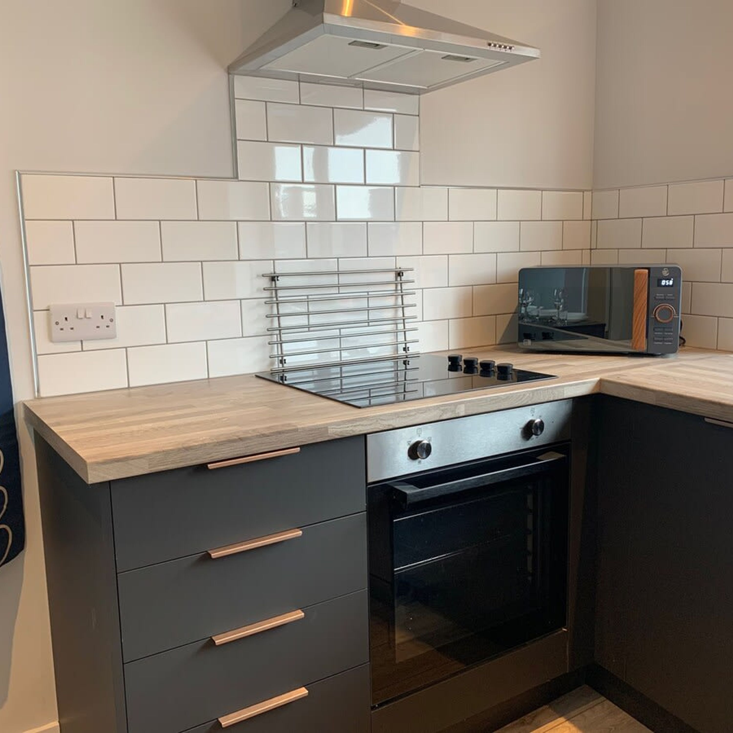 A modern kitchen with a gas stove, oven, and microwave.