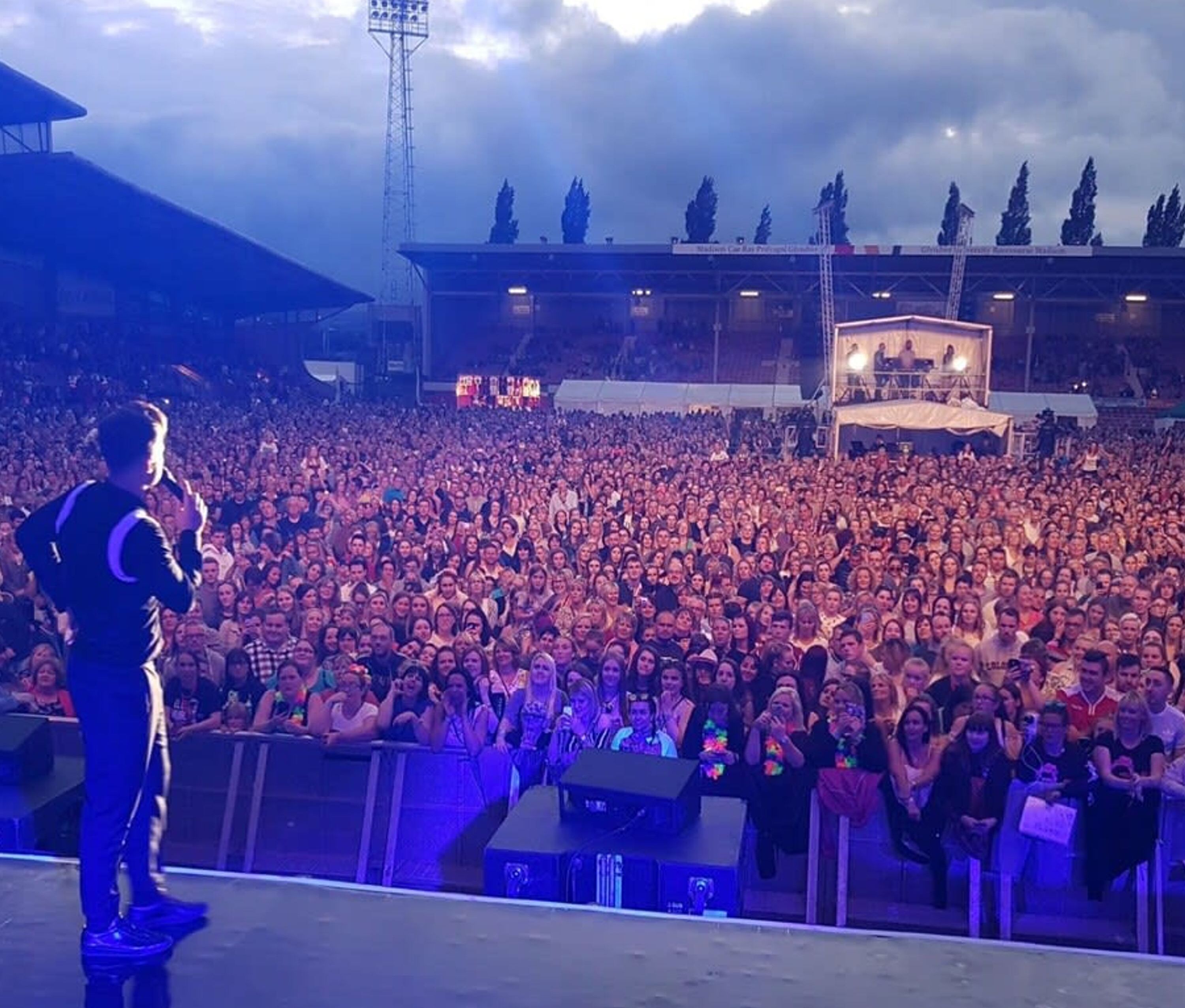 A large indoor venue with a stage at the front and a crowd of people.