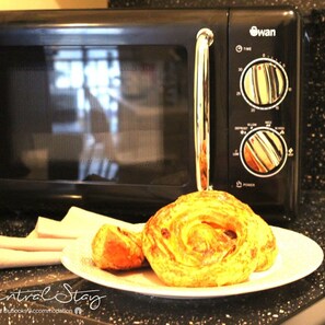 A black microwave with a plate of food on the counter. - Wrexham Central Stay Apartment Six (Wrexham)