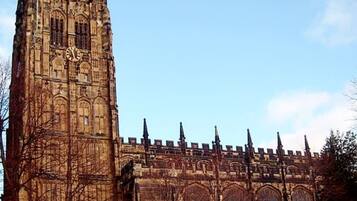 Un gran edificio de estilo gótico con una torre de reloj destacada y múltiples agujas.