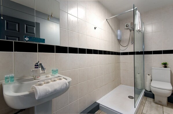 A modern bathroom with a white sink, a glass shower enclosure, and a white toilet. - The Maelor - Berwyn House Central Wrexham (Wrexham)