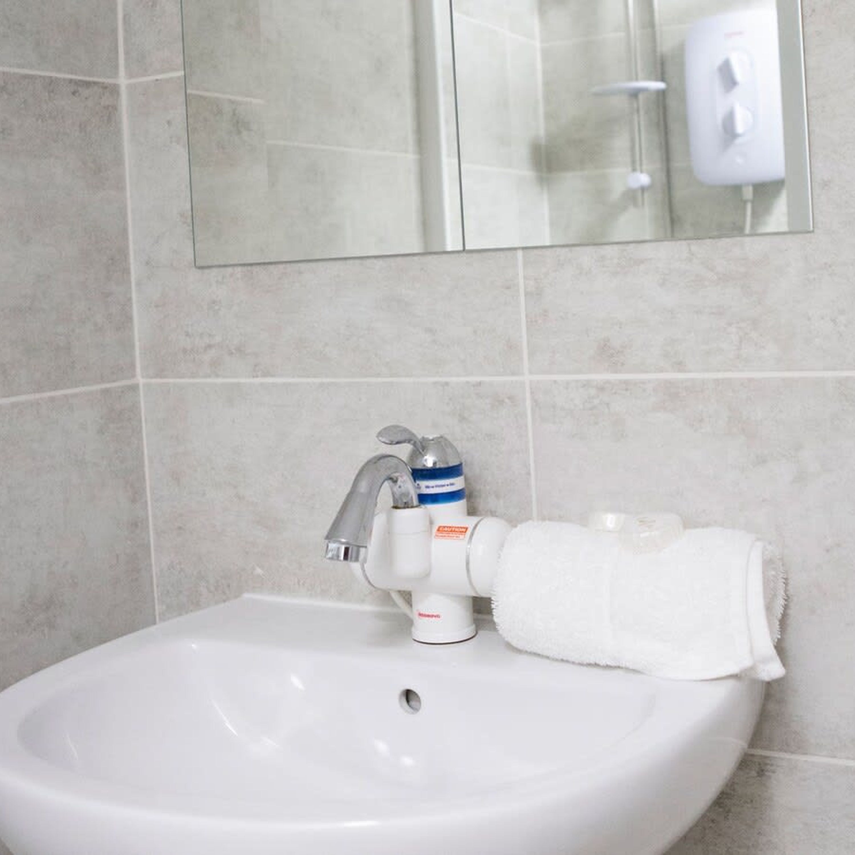 A bathroom sink with a faucet, a soap dispenser, and a towel.