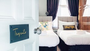 A hotel room with two beds, a minibar, and a sign indicating the minibar location.