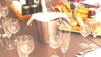 Una mesa de comedor dispuesta con copas de vino, platos, cubiertos y una variedad de alimentos.