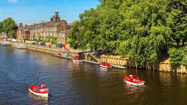 A river with boats, a bridge, and buildings along the riverbank.