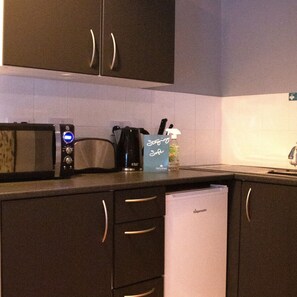 1 habitación, escritorio y tabla de planchar con plancha