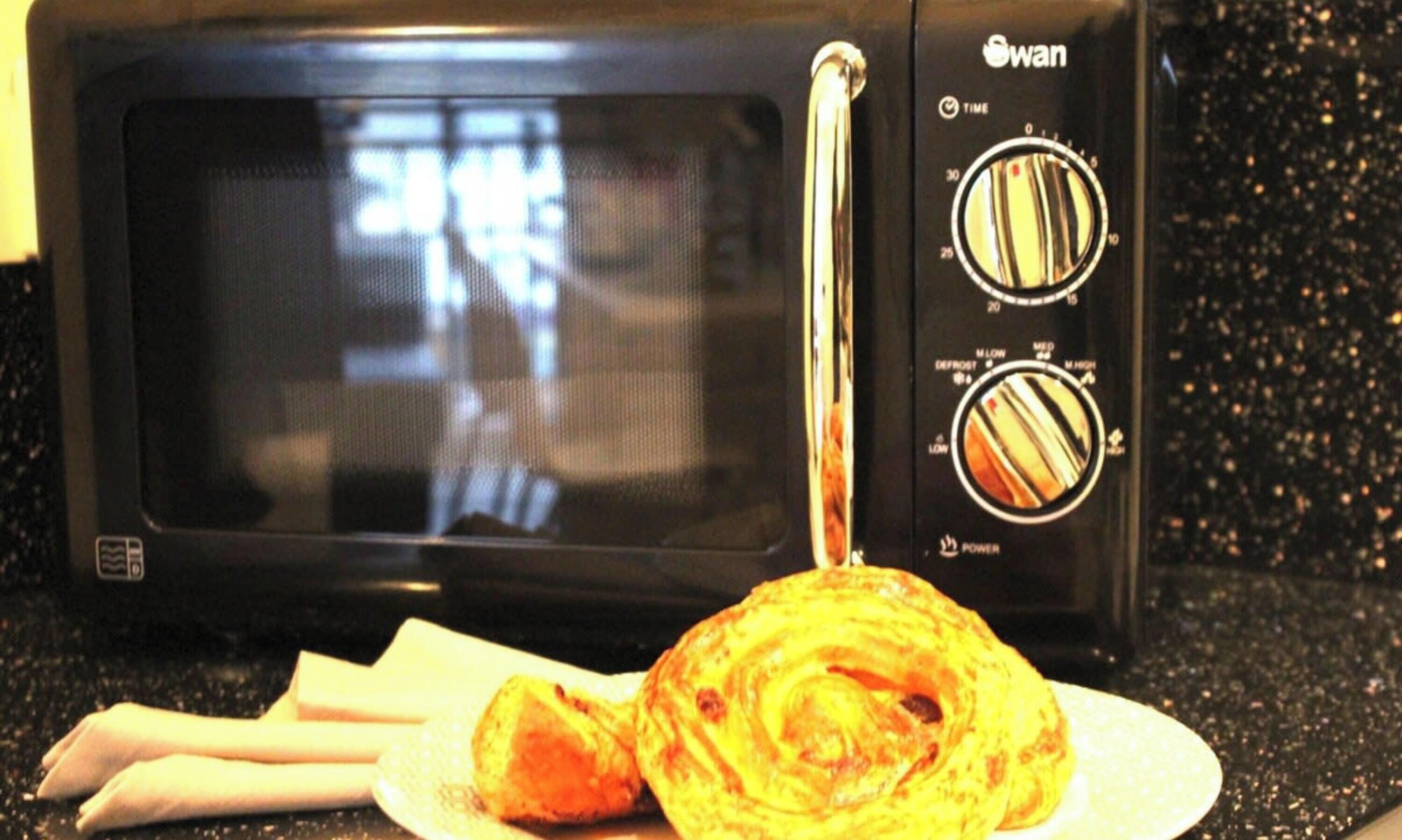 A microwave oven with a digital display and control knobs for time and power settings.